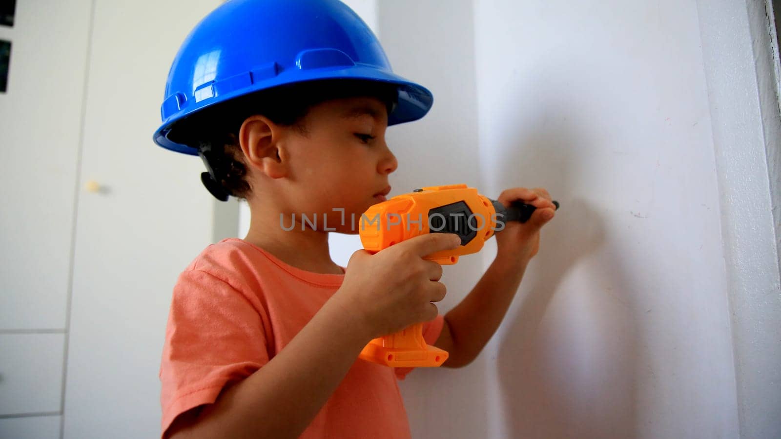 salvador, bahia / brazil - august 4, 2020: child wearing protective helmet plays construction.