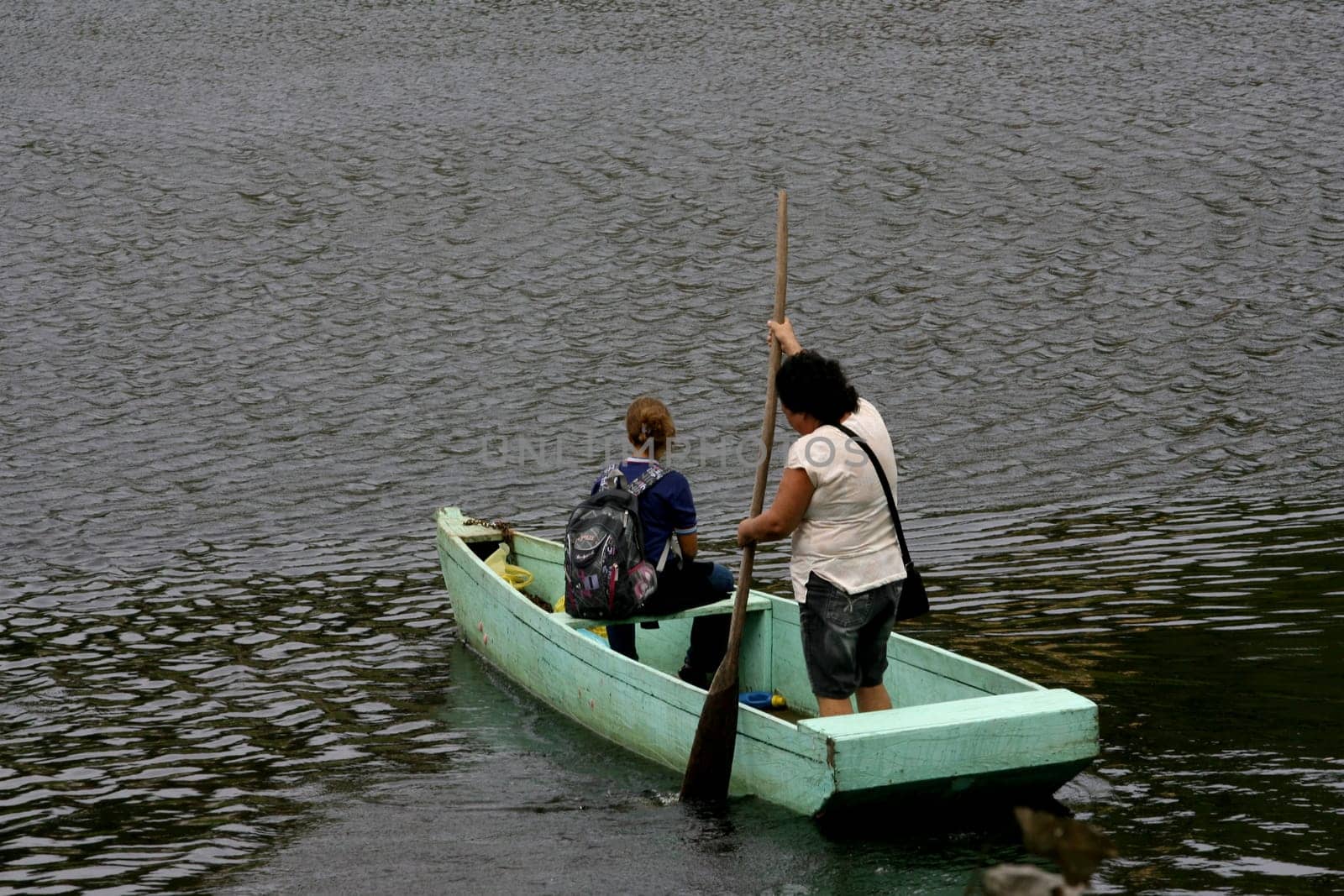 ilheus, bahia / brazil - june 20, 2011: woman is seen rowing a boat while crossing the Cachoeira river in the city of Ilheus, in the south of Bahia.