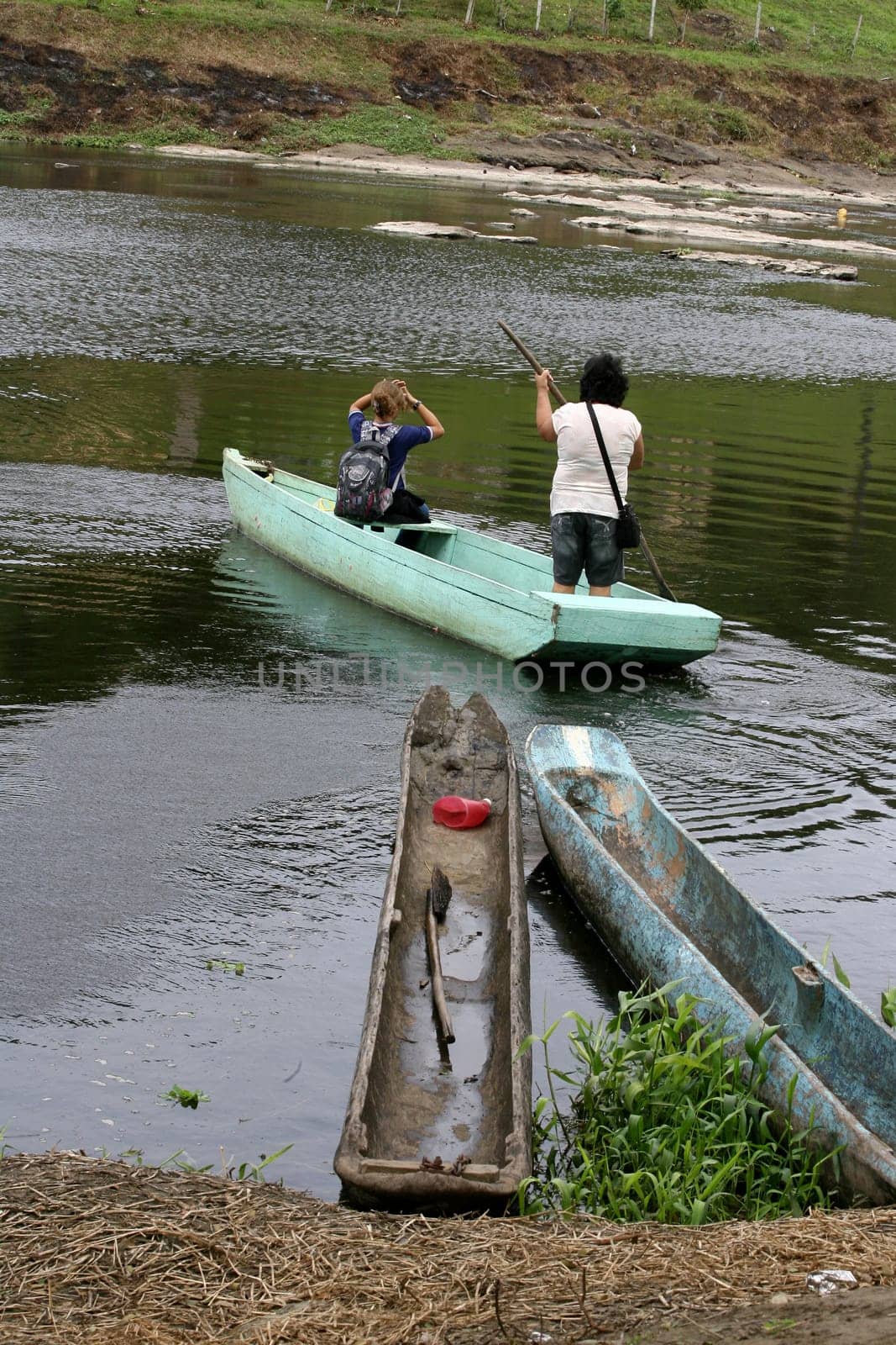 ilheus, bahia / brazil - june 20, 2011: woman is seen rowing a boat while crossing the Cachoeira river in the city of Ilheus, in the south of Bahia.