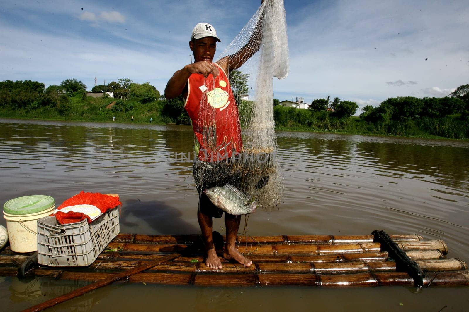 itabuna, bahia / brazil - december 20, 2011: fisherman is seen on a raft in the waters of the Cachoeira river in the city of Itabuna, southern Bahia.