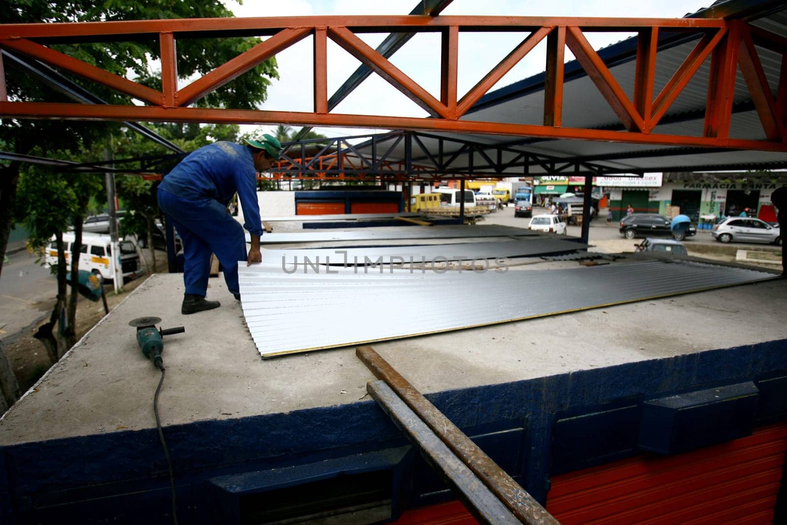 itabuna, bahia / brazil - december 7, 2011: workers work on the roof structure of a shed at the open market in the city of Itabuna.