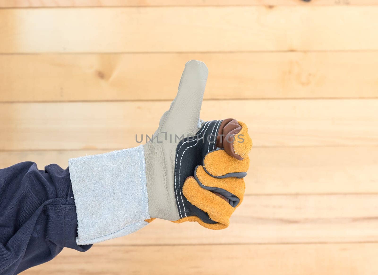 Working hand in Rough leather glove with wall wood background