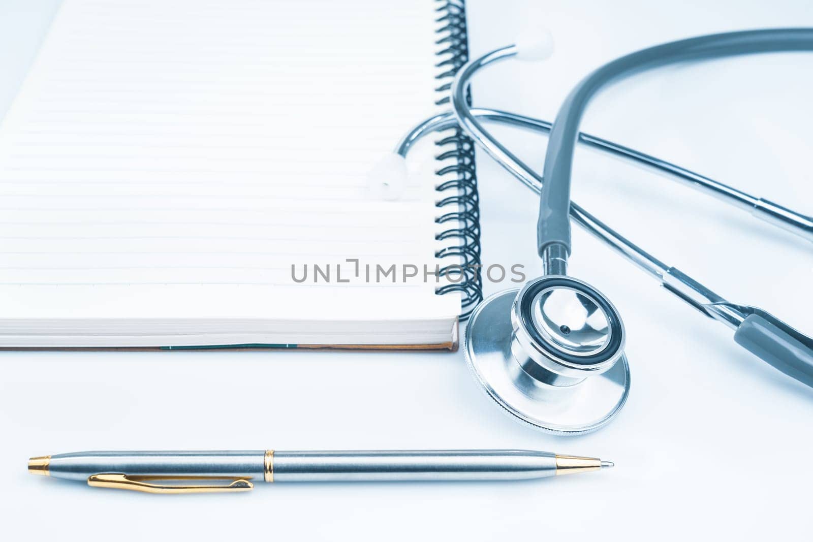 Close up Medical stethoscope for doctor checkup on health medical laboratory table with notepad as medical concept