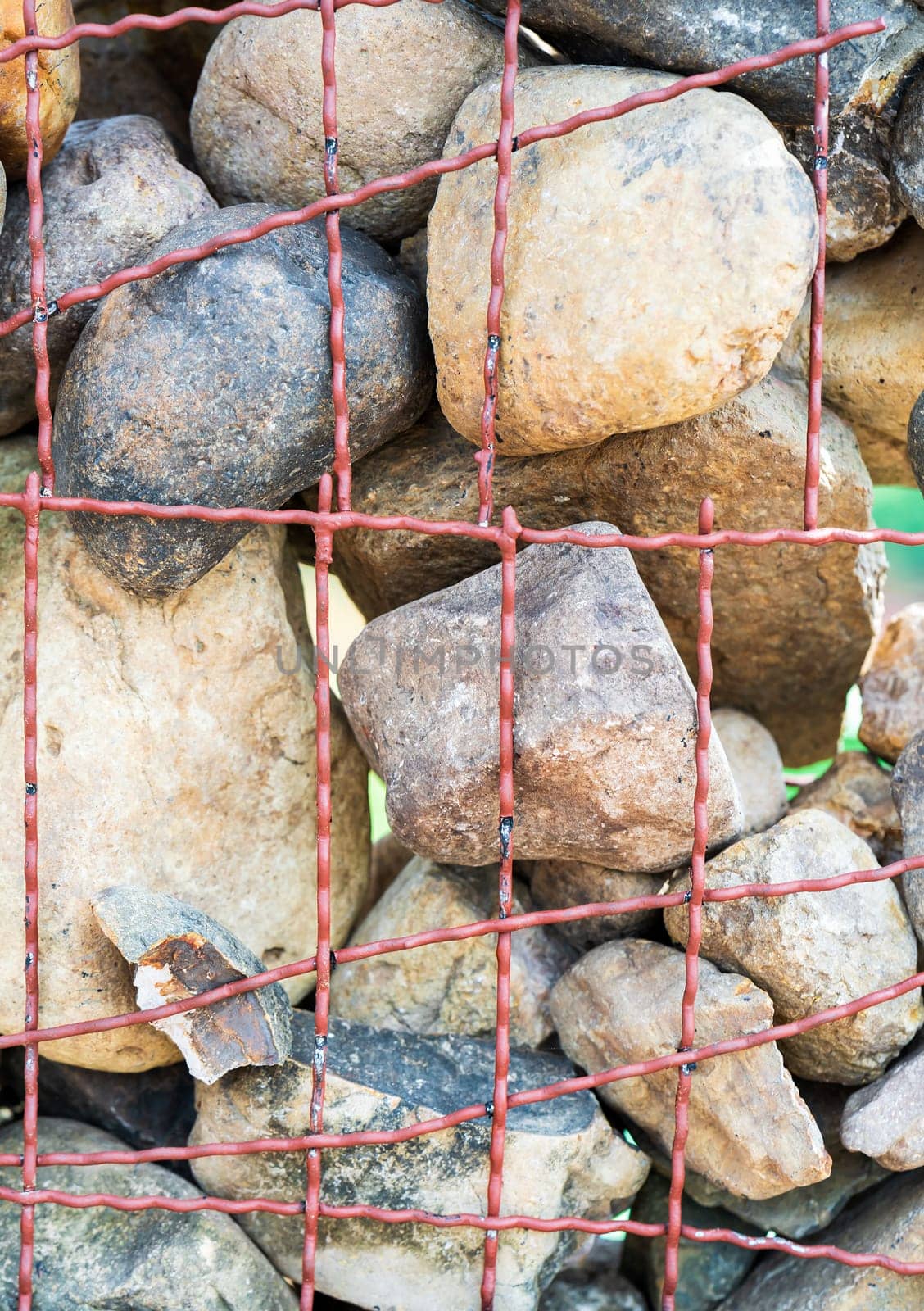 The fence of the wall made of stone The stone wall is tied around with steel bars element of design for garden landscaping