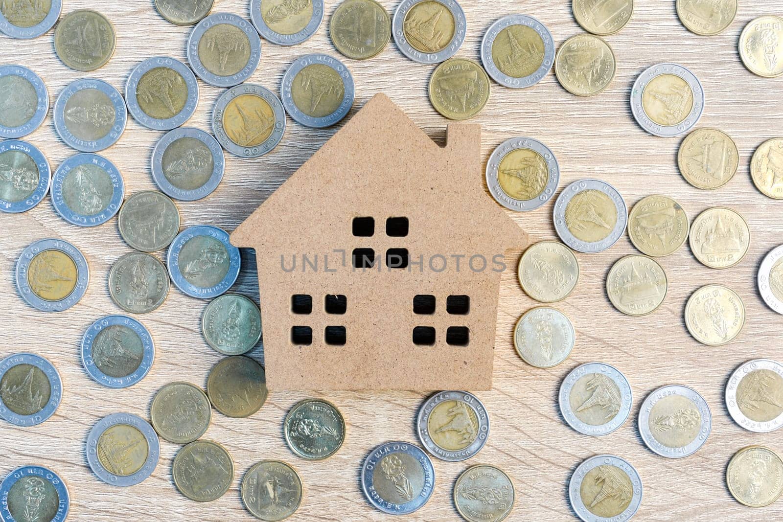 Top view house and coins on wood table using as property real estate and financial concept