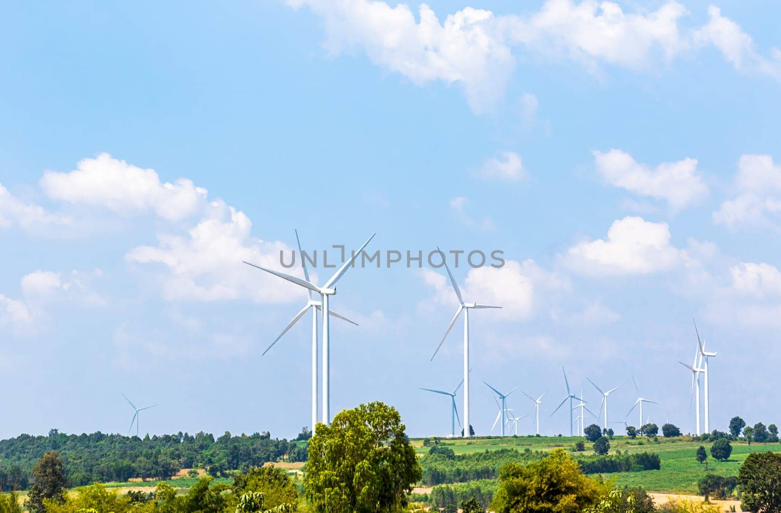 Wind turbine  generators line the hilltops and Aerial landscape with blue sky