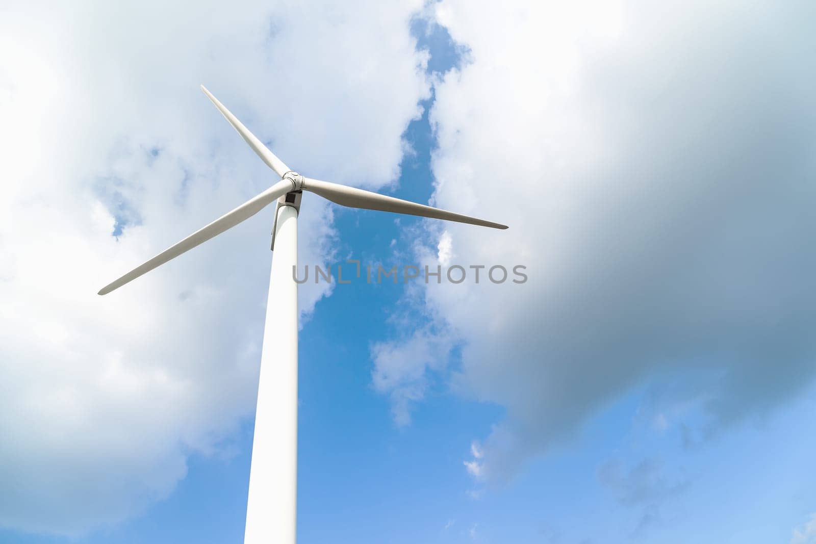 Close up Wind turbine  generators against a cloudy blue sky