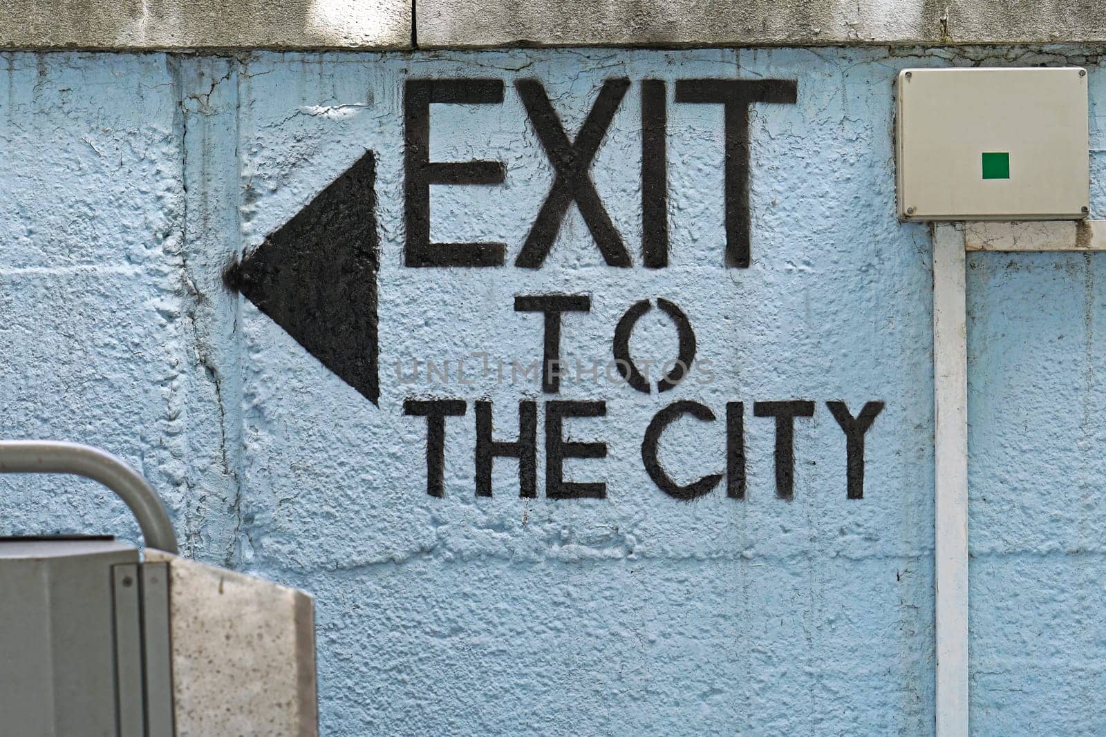 Exit to the city sign with arrow at wall