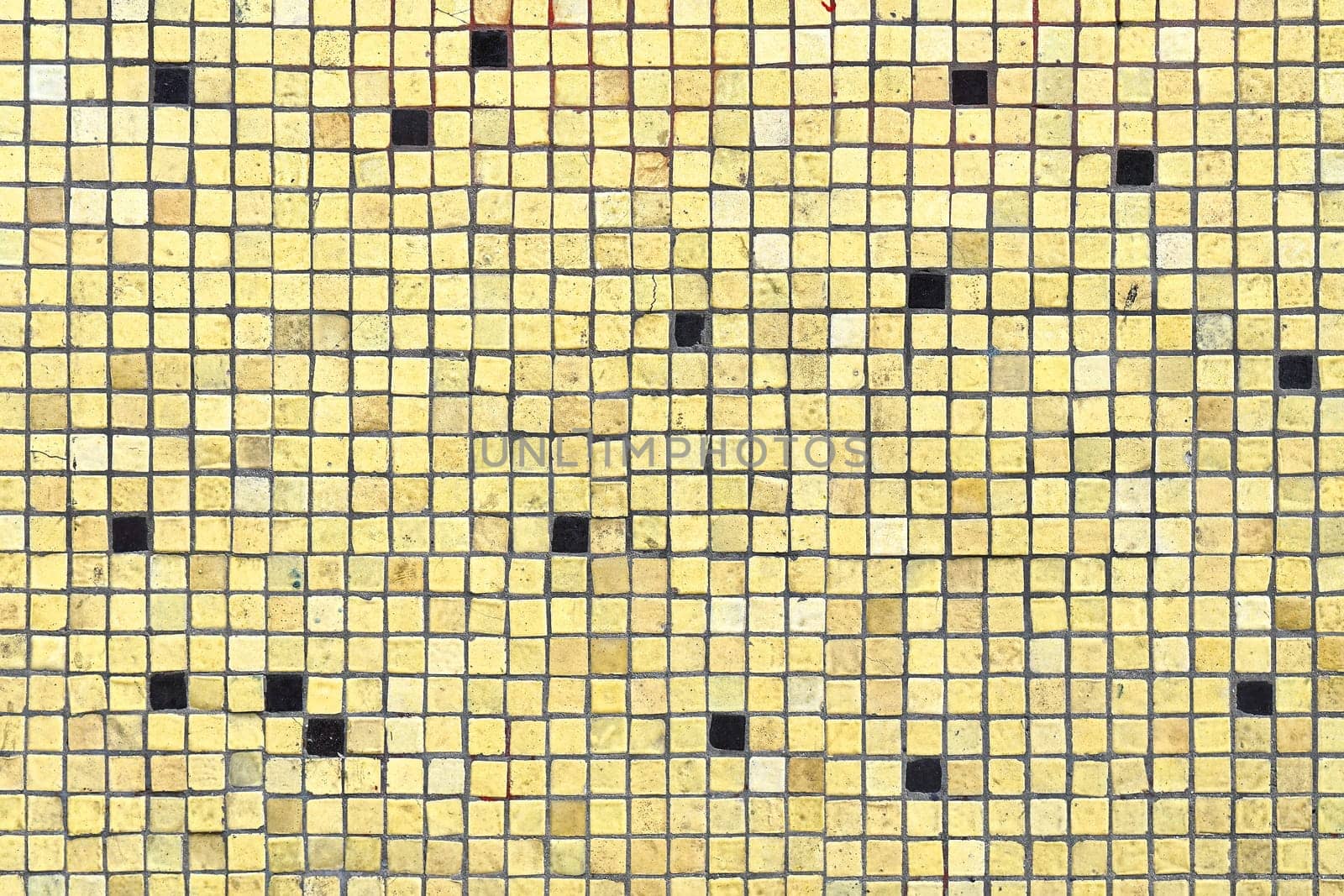 Grunge yellow small mosaic tiles wall