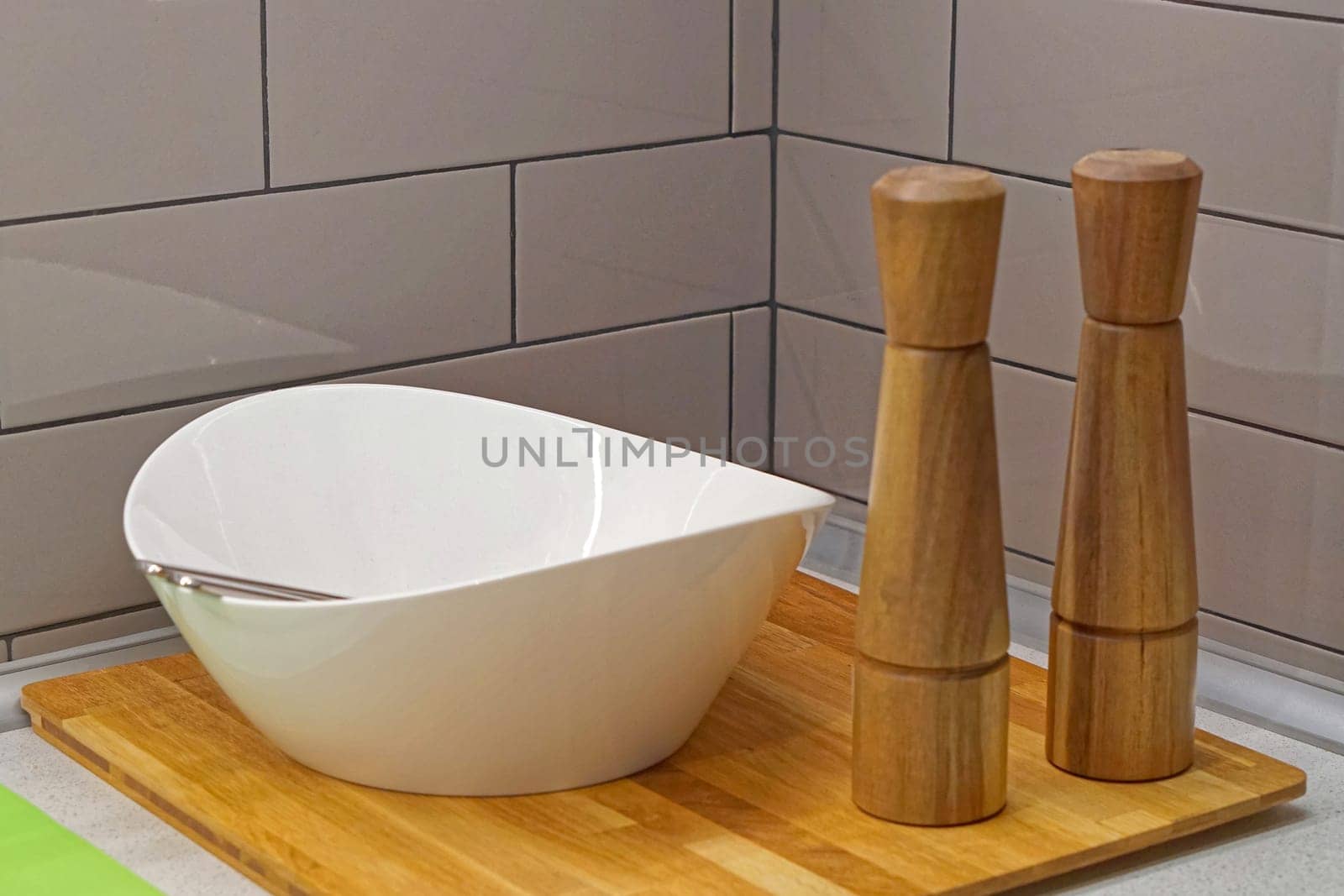 Ceramic salad bowl and grinders at wooden tray kitchen set