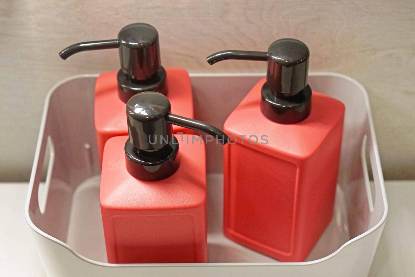 Three modern bathroom soap dispensers in crate