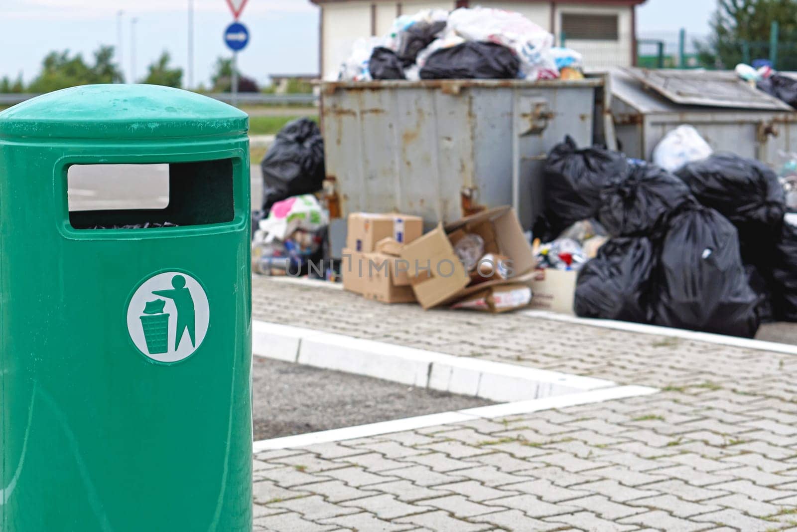 Overflow of garbage litter and empty trash can
