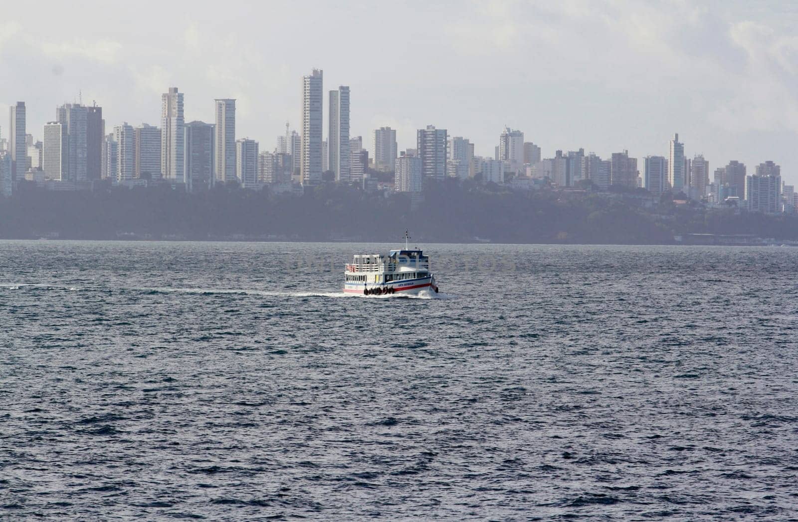 salvador, bahia / brazil - november 3, 2014: motorboat is seen sailing through Baia de Todos os Santos during the crossing from Vera Cruz Island to the city of Salvador.