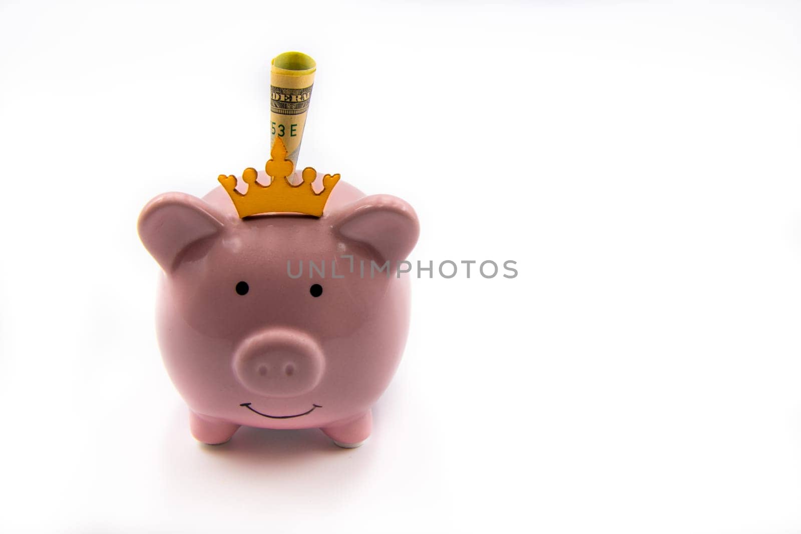 Pink piggy bank with golden crown and USD banknote isolated over white background with copy space, cash is king concept image