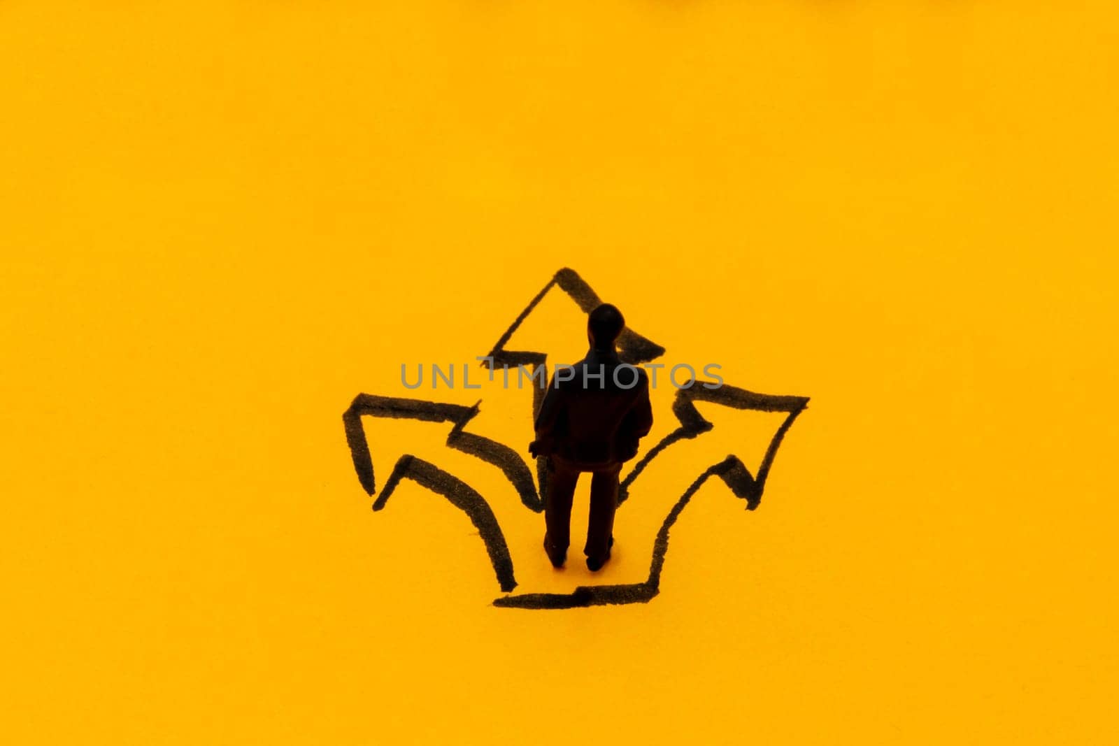 Miniature figurine posed as businessman at the crossroads, decision concept image