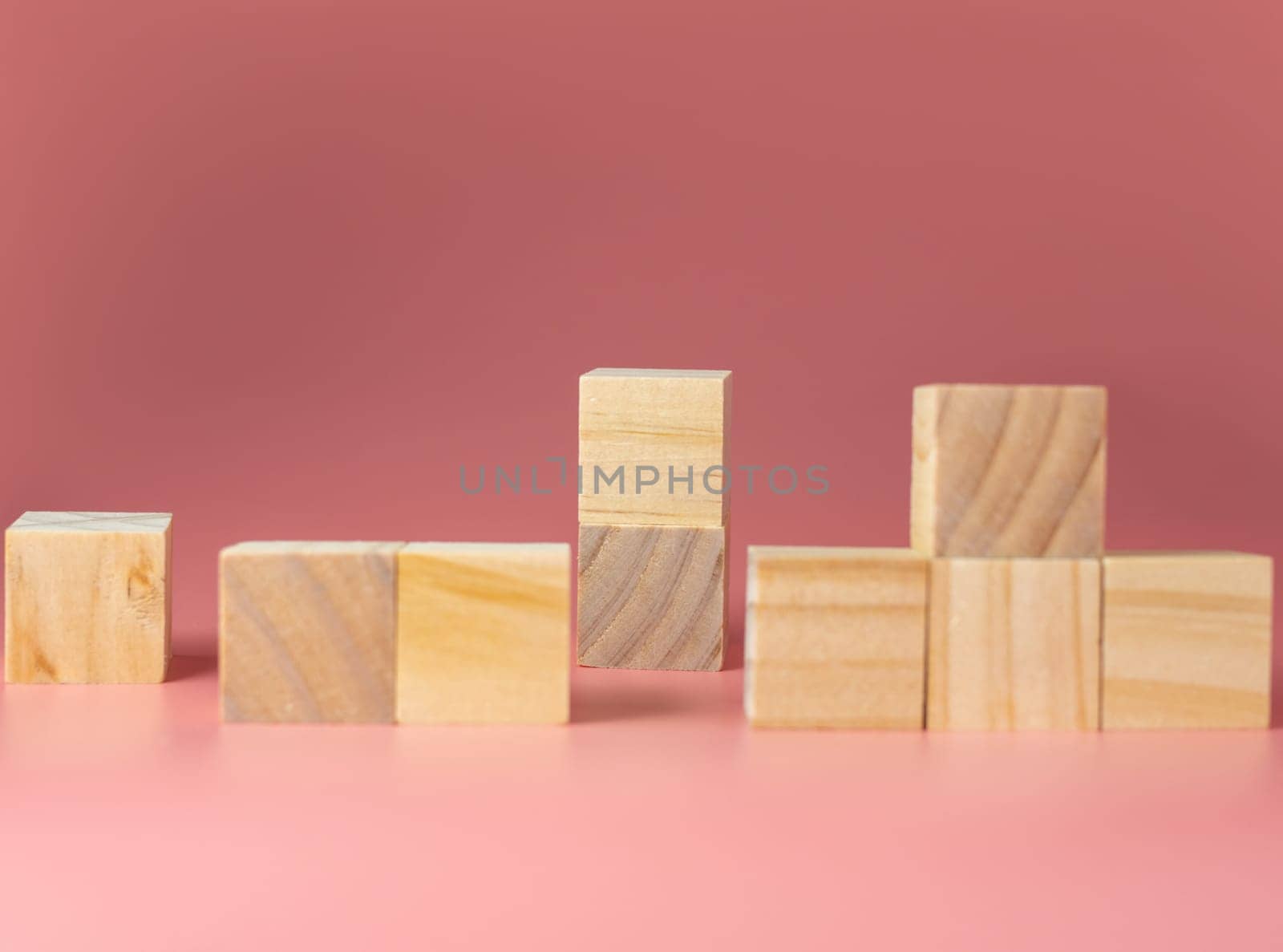 Empty wooden cube on a pink background. For new ideas to be put into the picture.Rear focus.