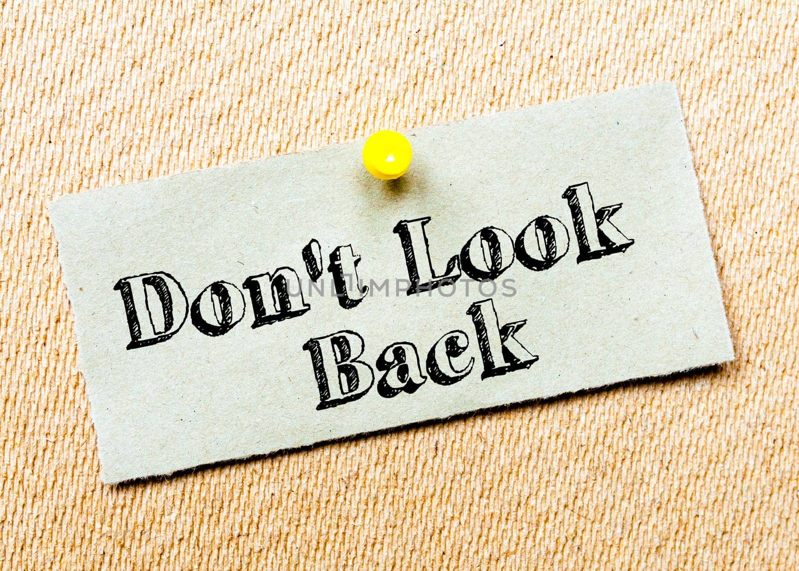 Recycled paper note pinned on cork board. Don't Look Back message. Concept Image