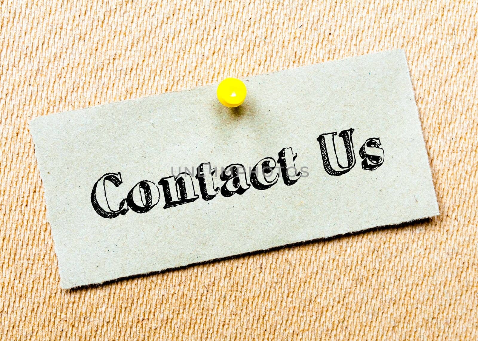 Recycled paper note pinned on cork board.Contact Us Message. Concept Image