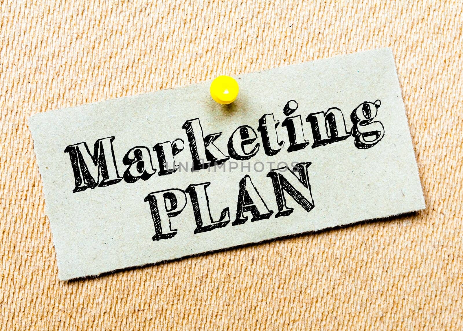 Recycled paper note pinned on cork board. Marketing Plan message. Concept Image