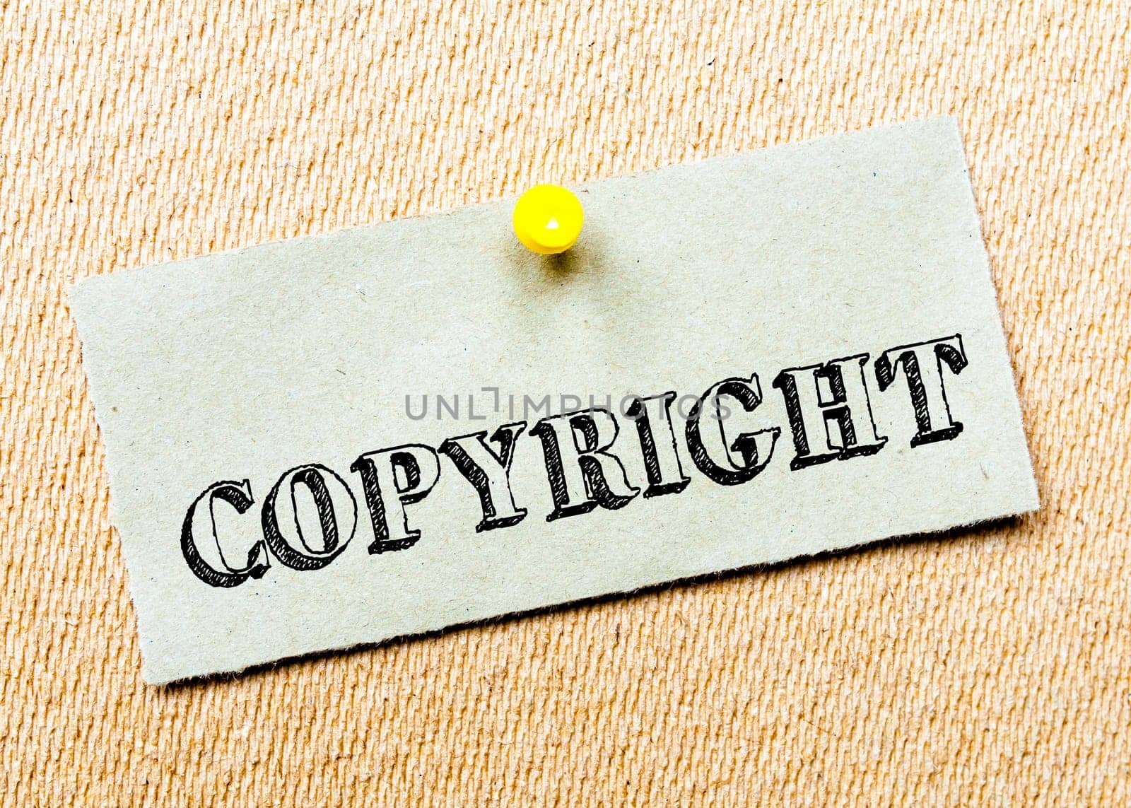 Recycled paper note pinned on cork board. Copyright Message. Concept Image