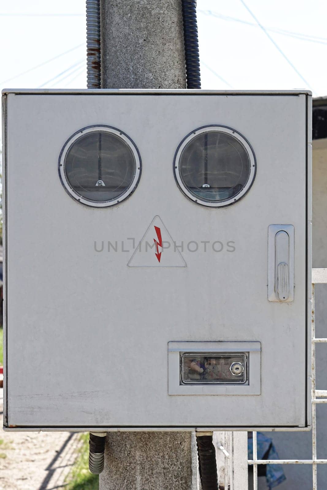 Electricity meter box with round windows at pole