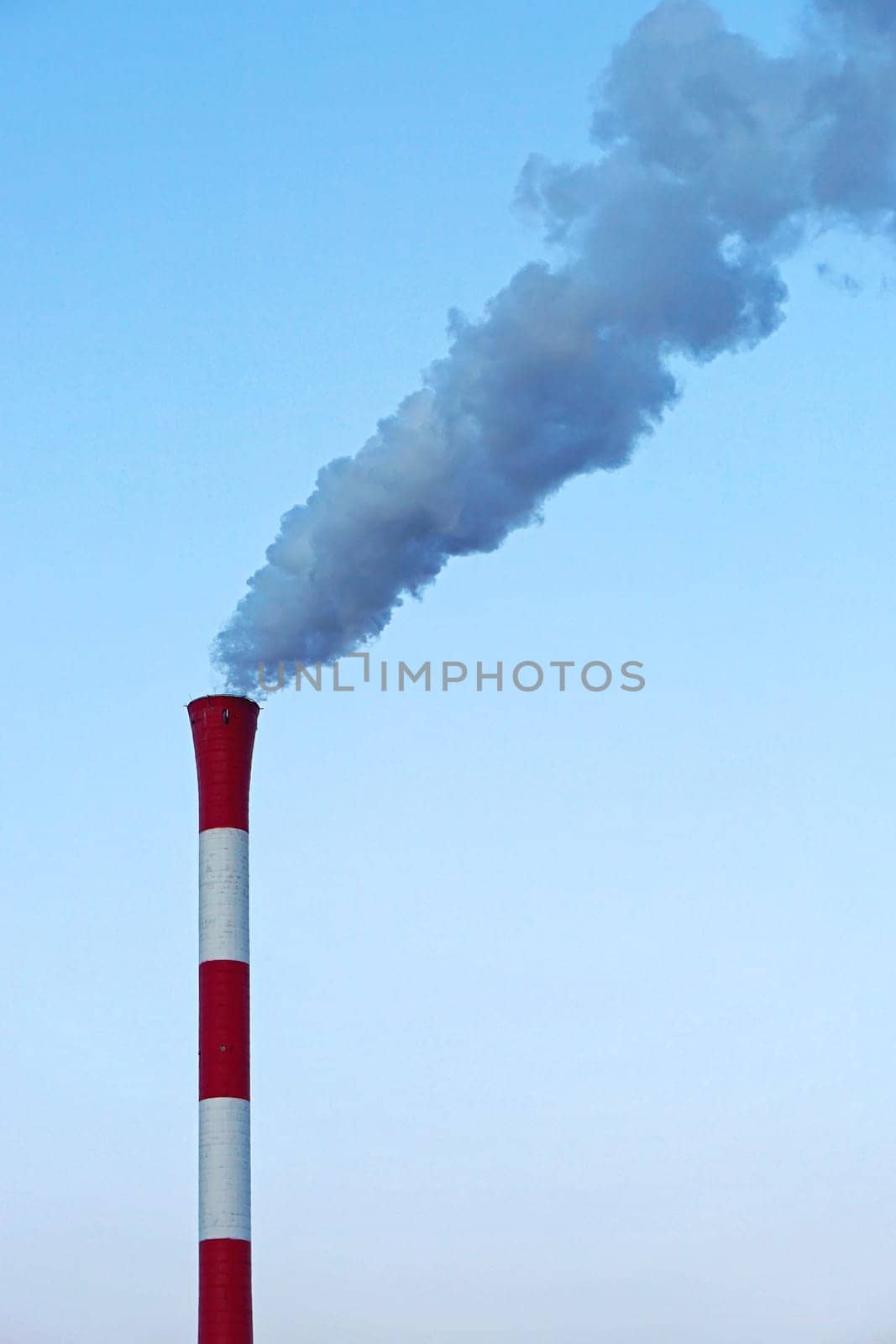 Red and white chimney with smoke