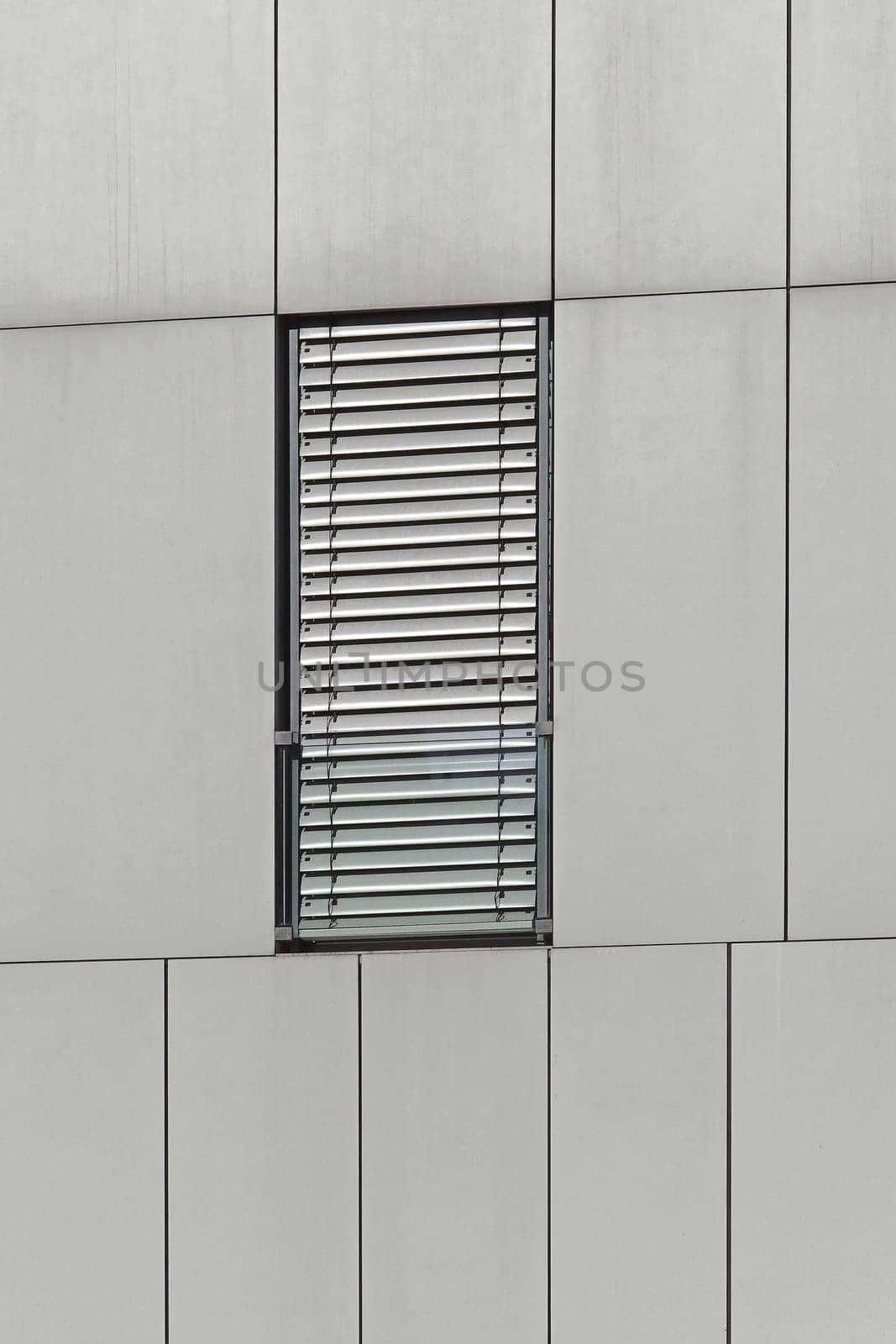Rectangular window with metal blinds at modern building