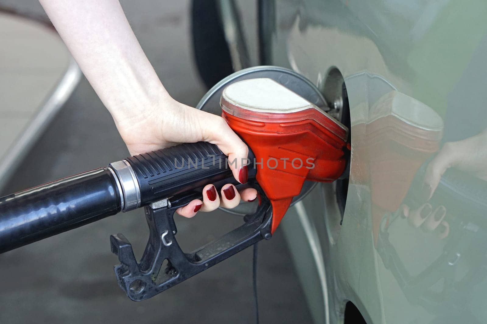 Woman filling car with gas at petrol station