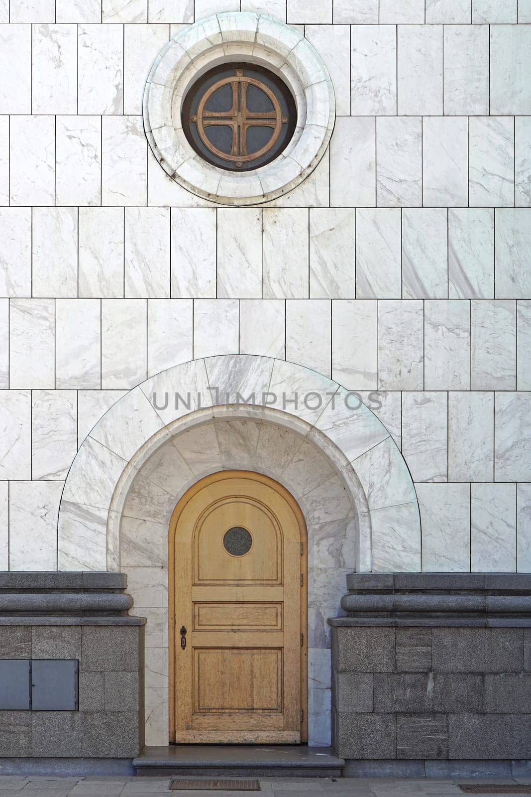 Arch door and round window at marble church in Belgrade