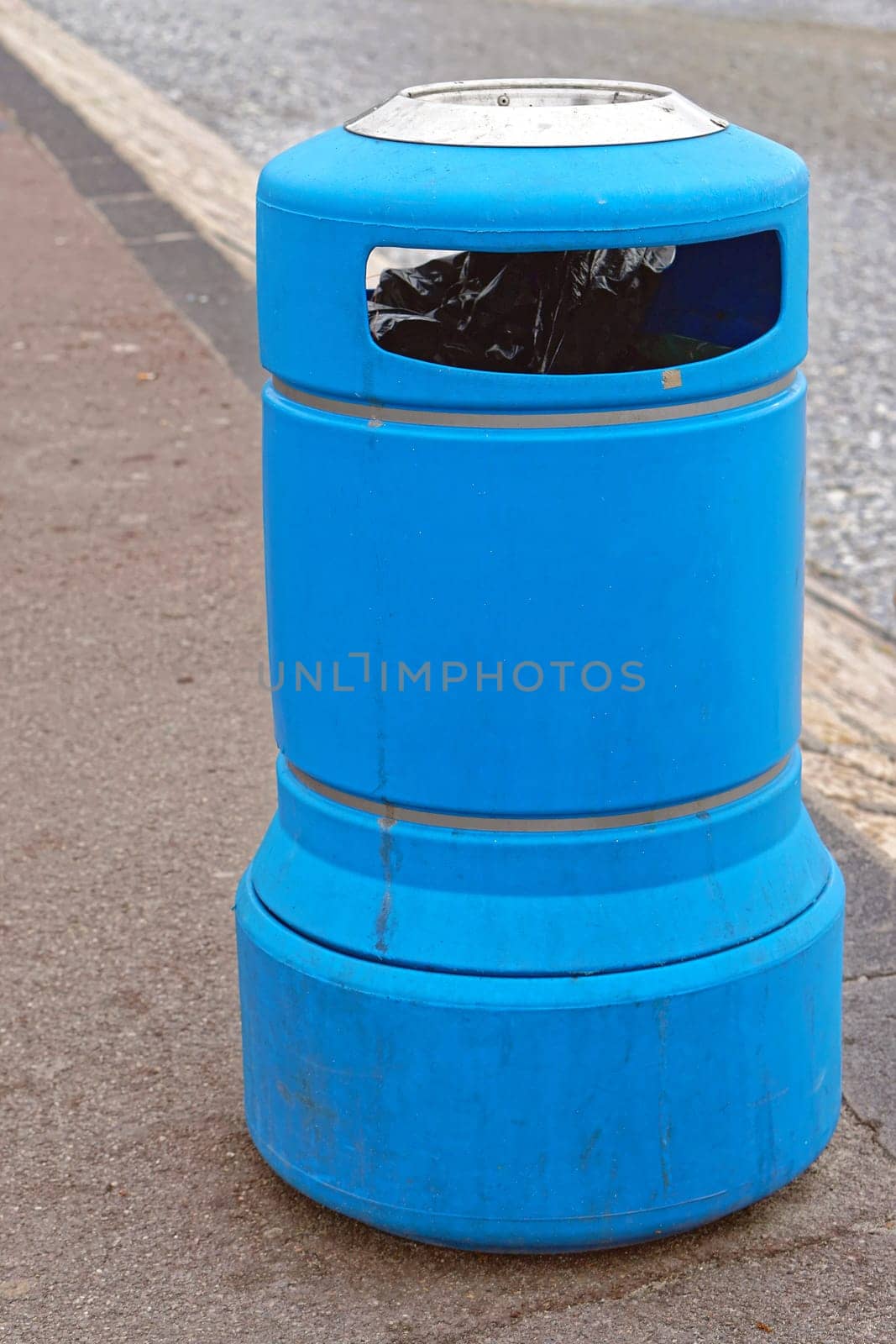 Blue plastic trash can at street