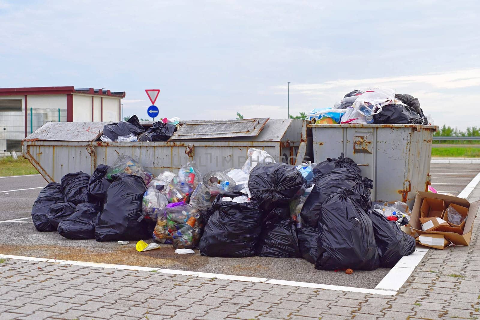 Overflow of garbage litter and empty trash can