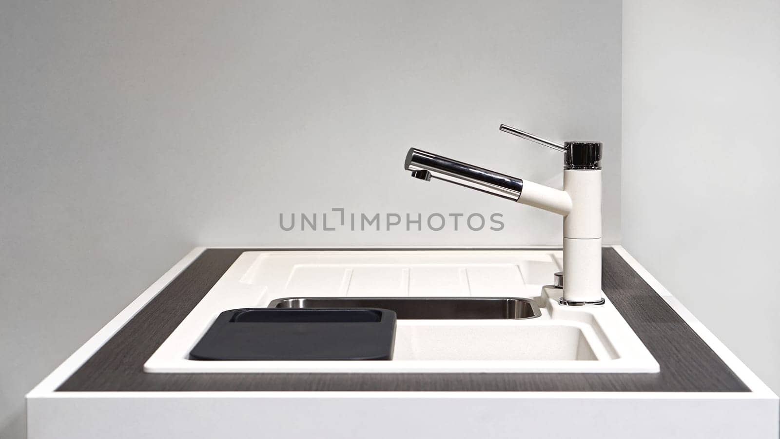 White kitchen sink with modern faucet