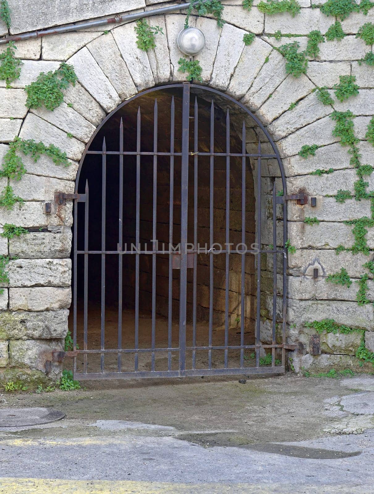 Stone arch doorway with iron bars door