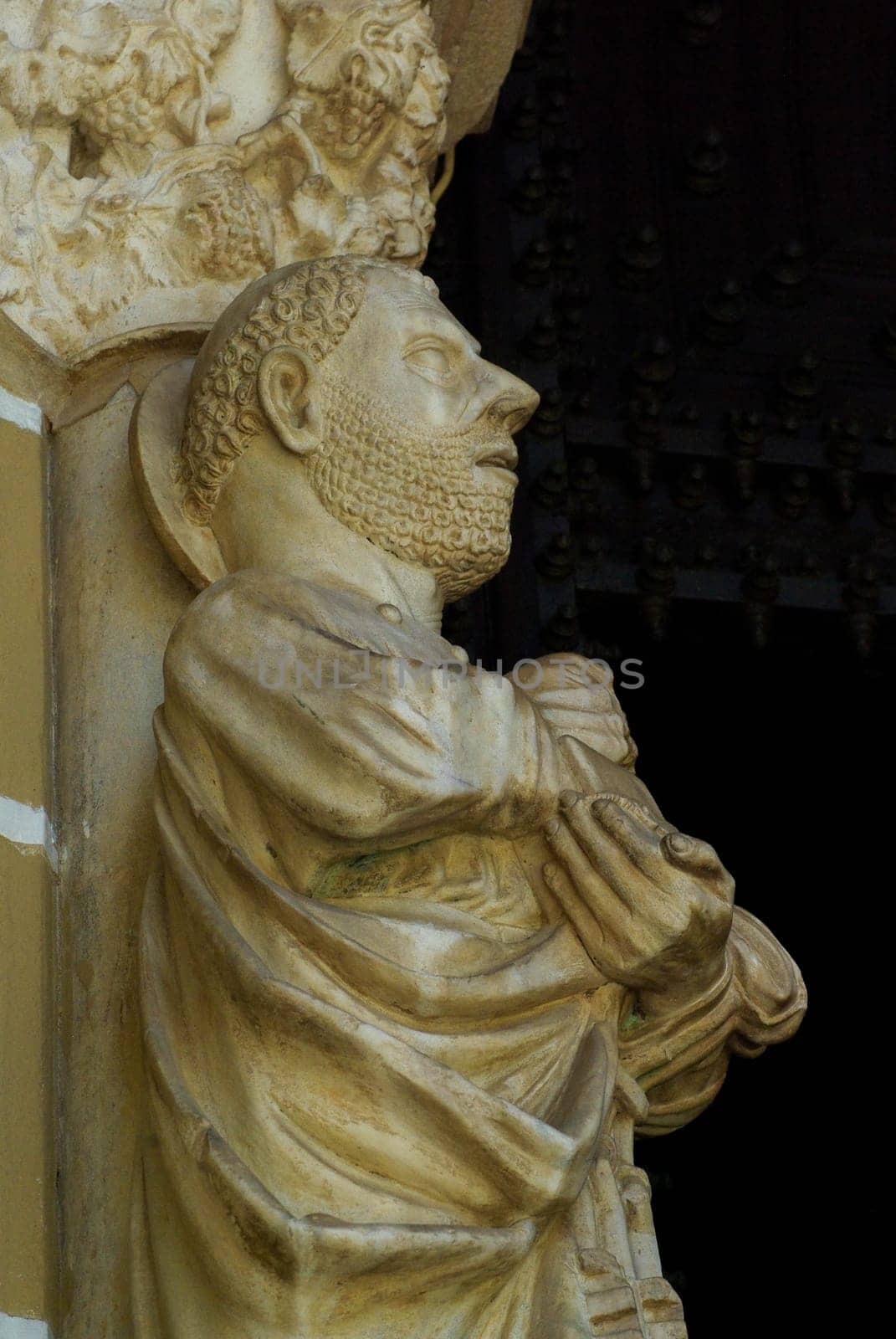 Fourteenth century statue of St. Peter stands outside the entrance of Sé Cathedral in Évora Portugal. Shot in natural sunlight with copy space.