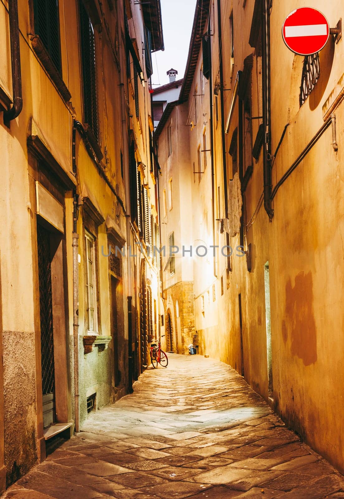Narrow street in the historic part of Lucca, Italy at night