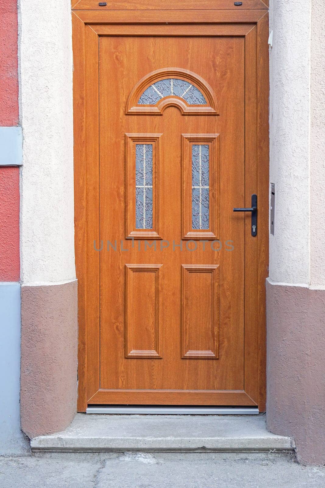 Brown wood door with big transom light window