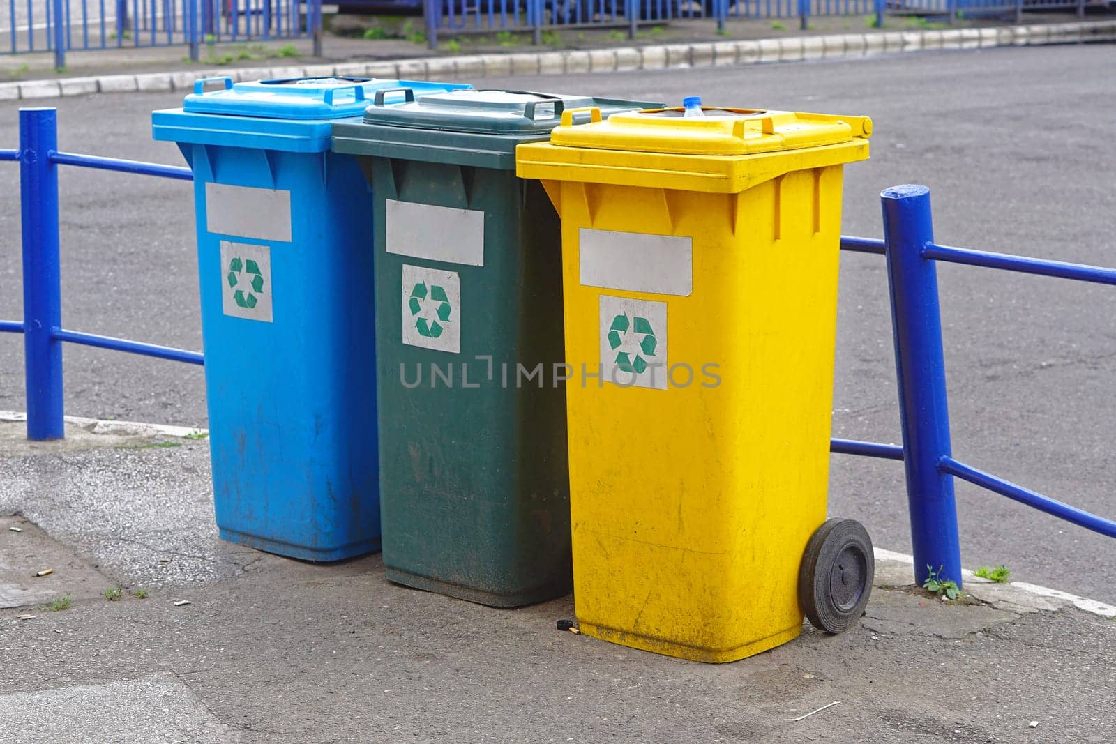 Three plastic recycling bins for sorting waste