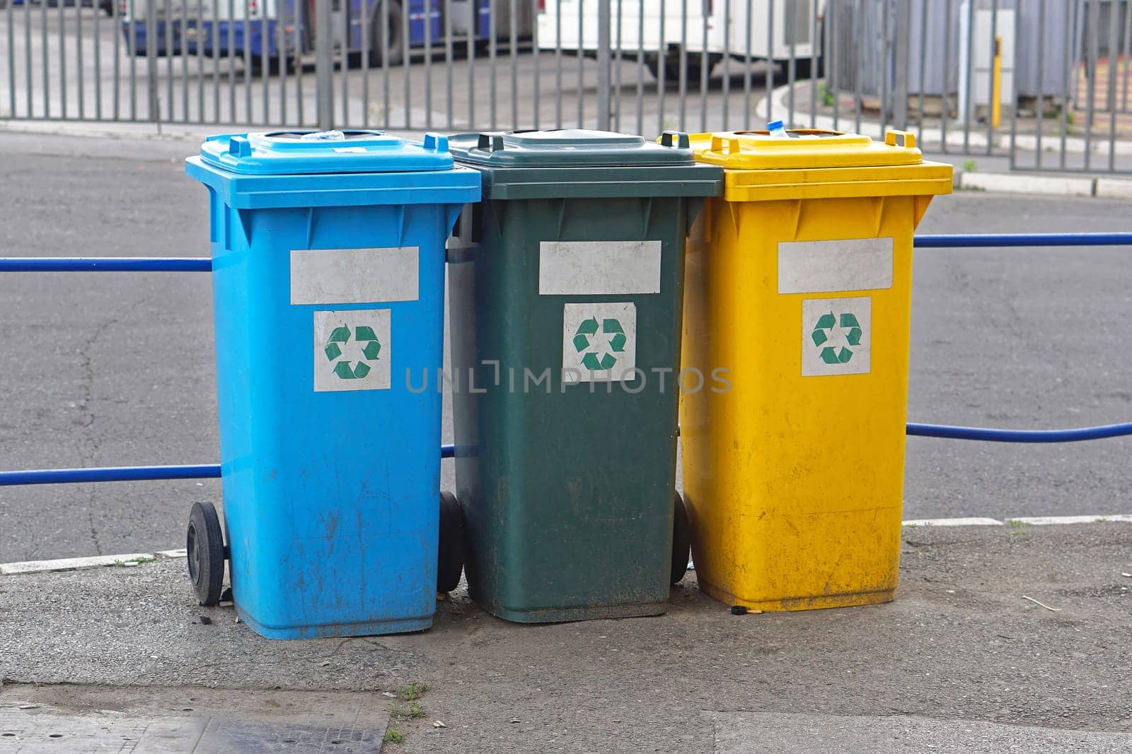 Three plastic recycling and sorting bins