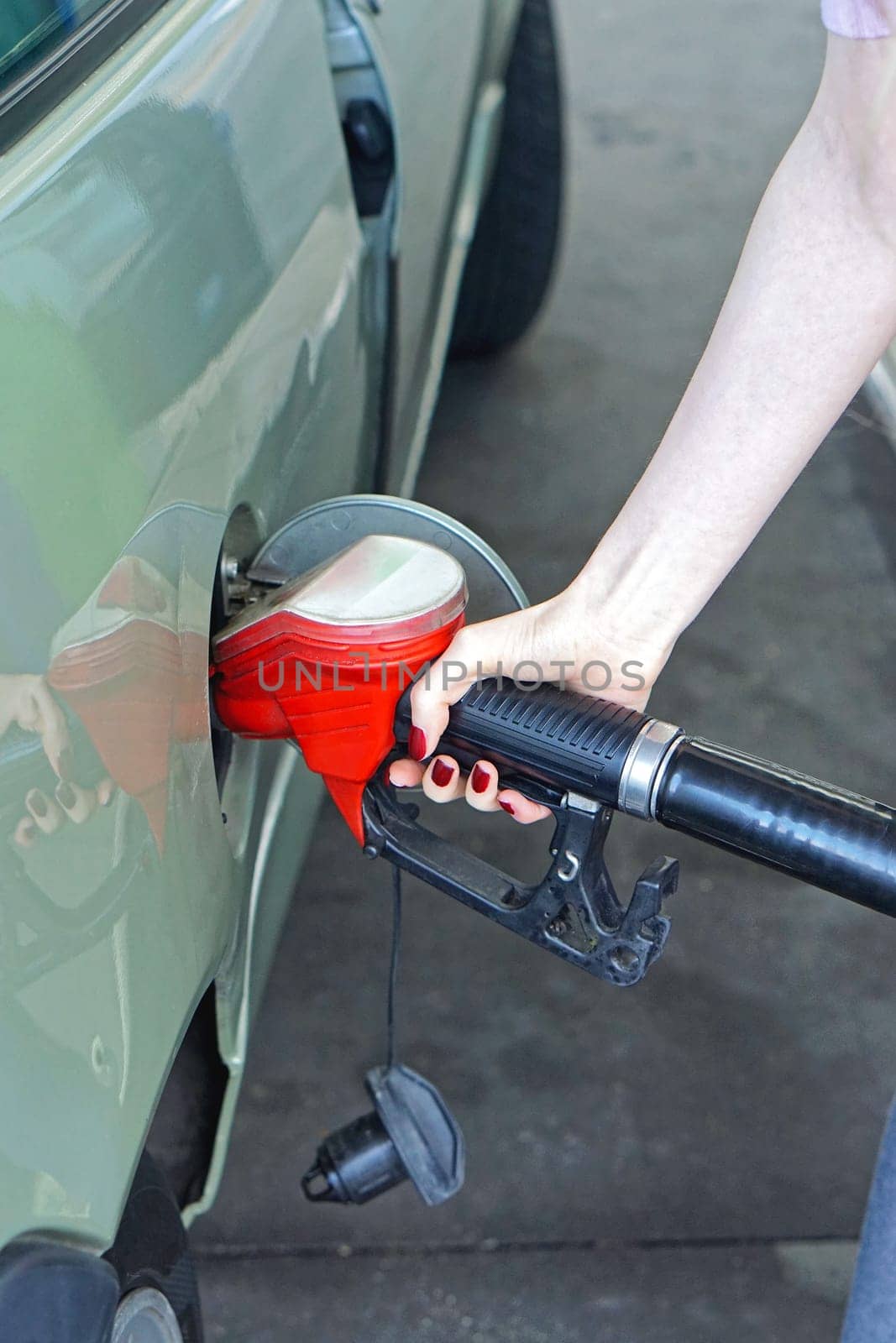Woman filli up car with gas at petrol station