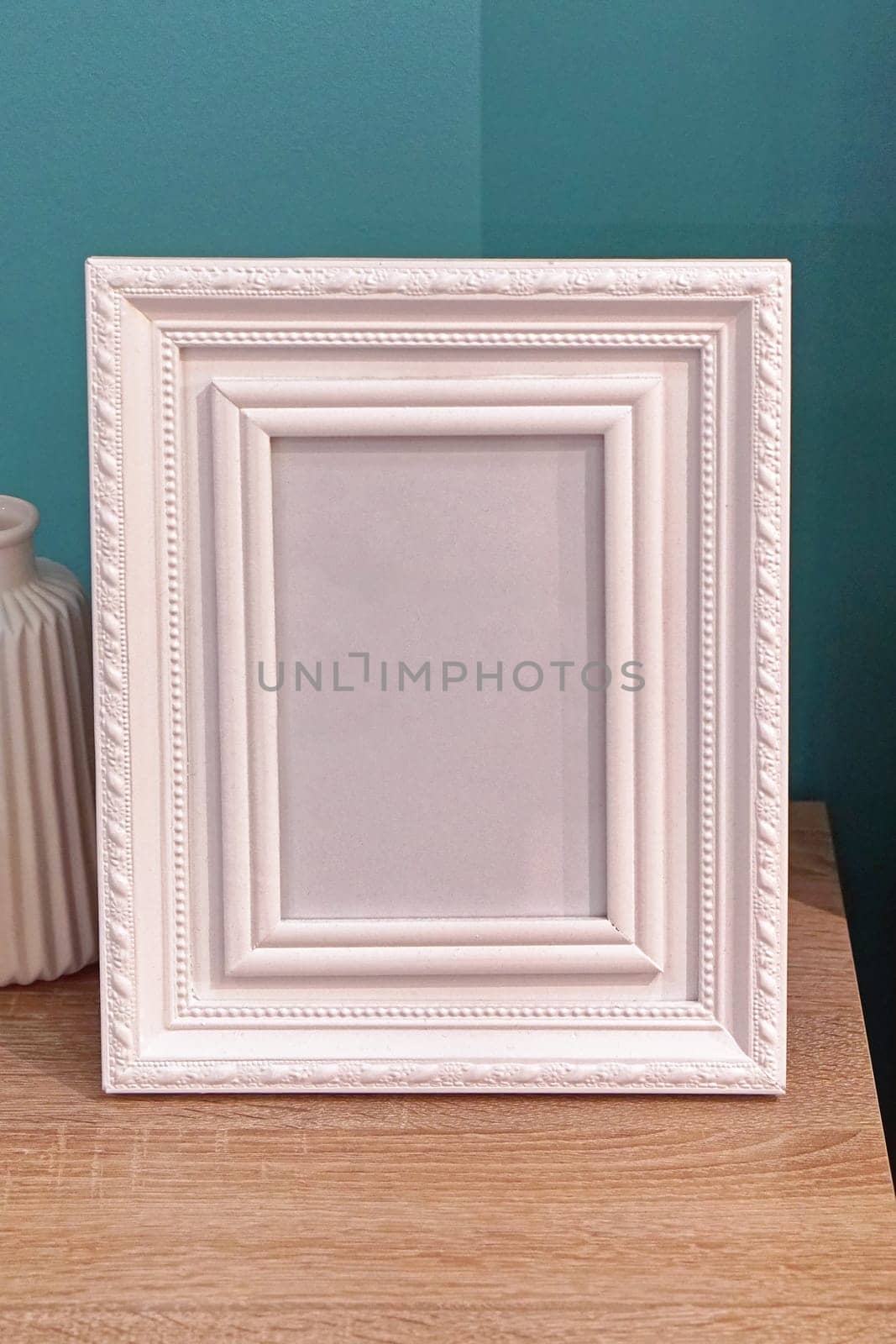 White portrait picture frame at table