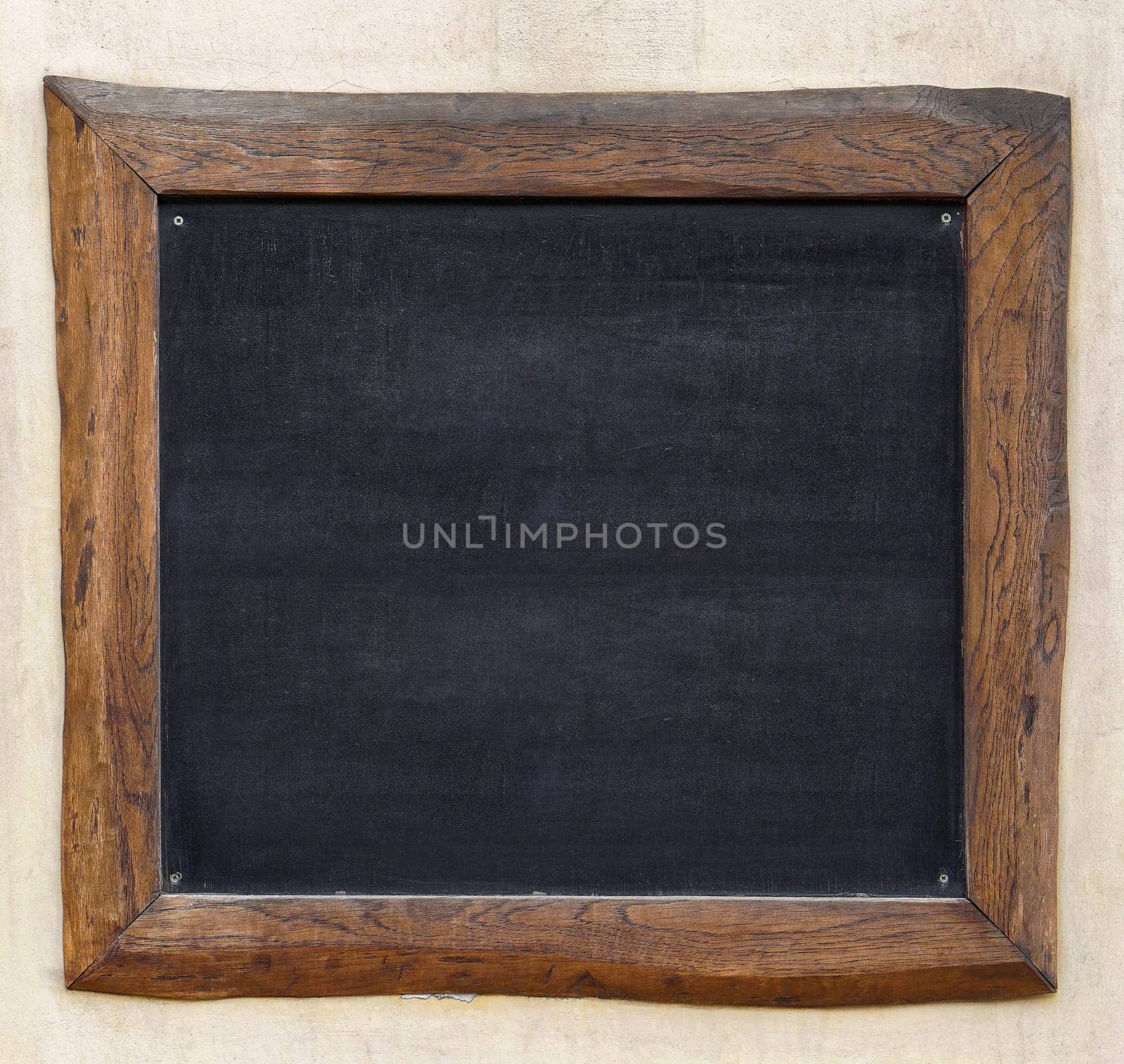 Blackboard with wooden frame at wall