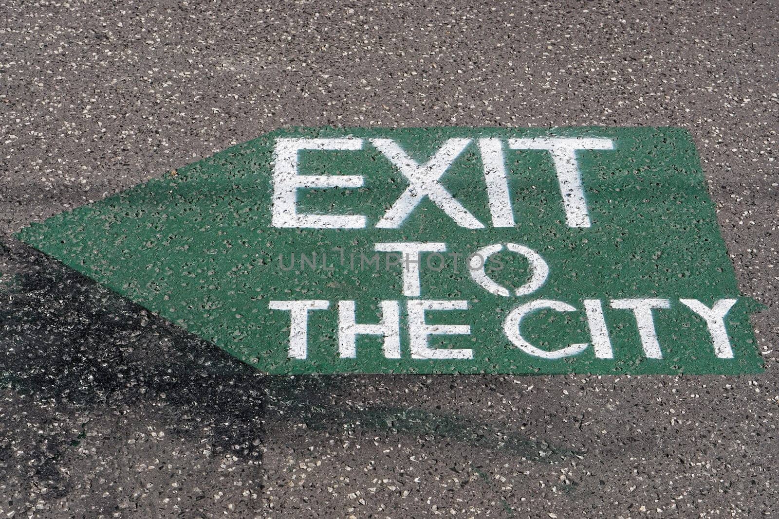 Exit to the city sign with arrow at pavement