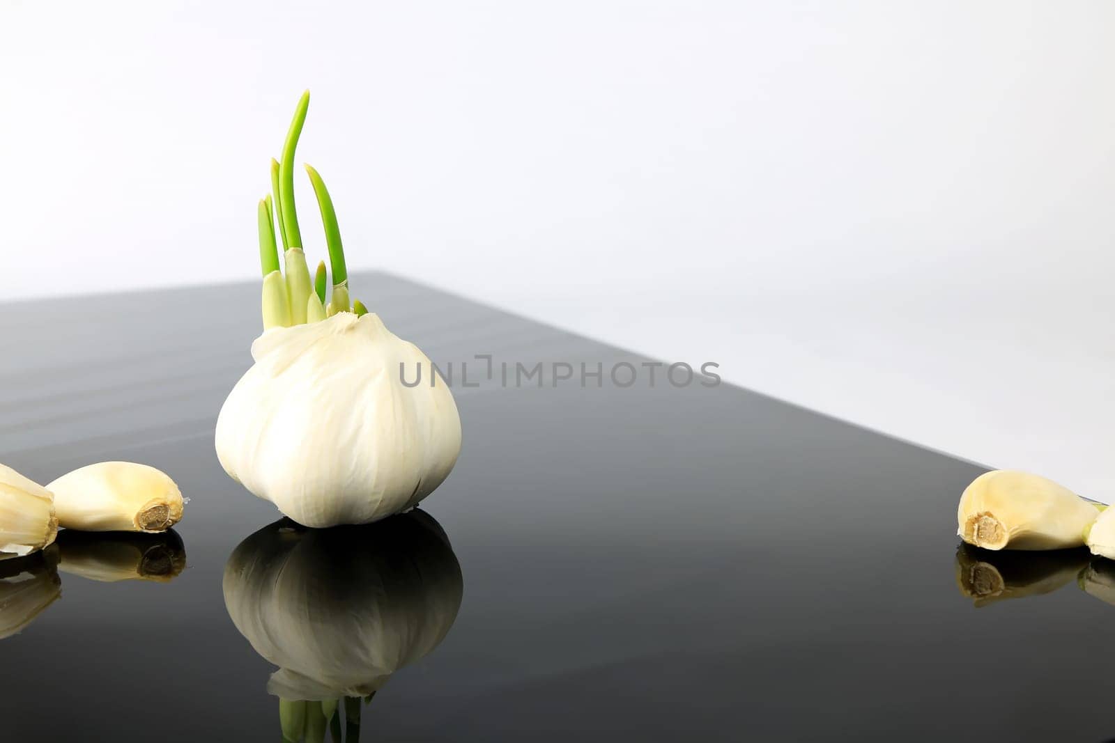 Garlic on a black plate wanders across the picture