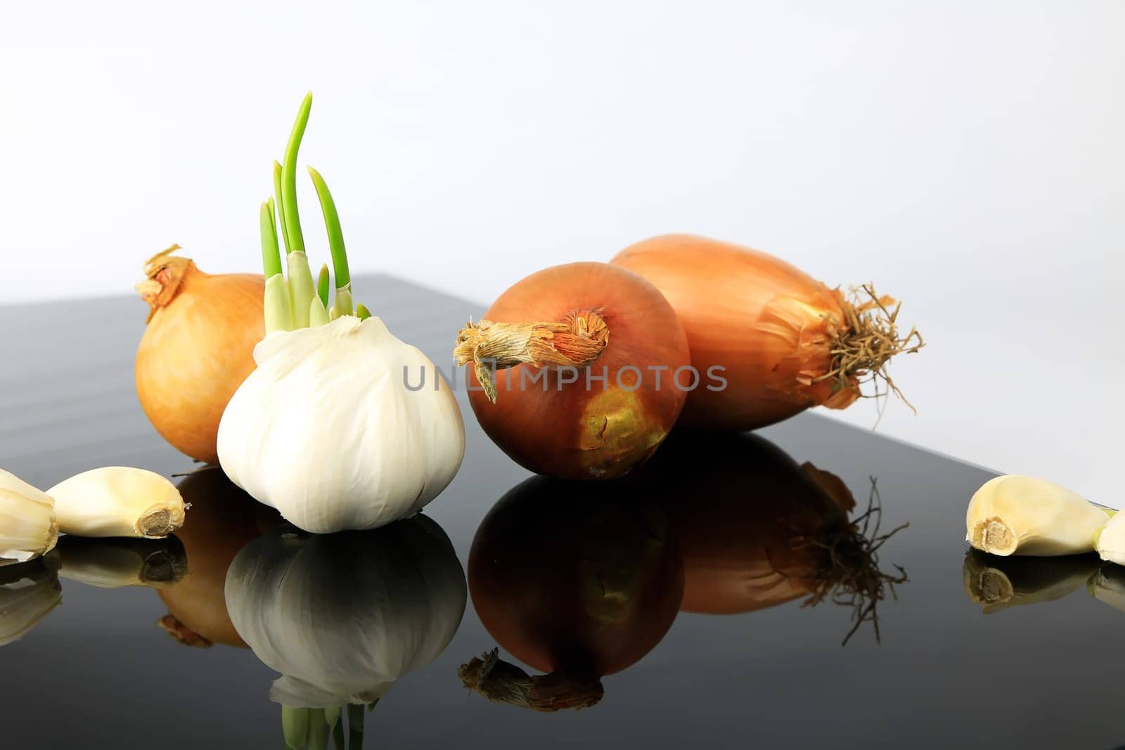 Garlic on a black plate wanders across the picture
