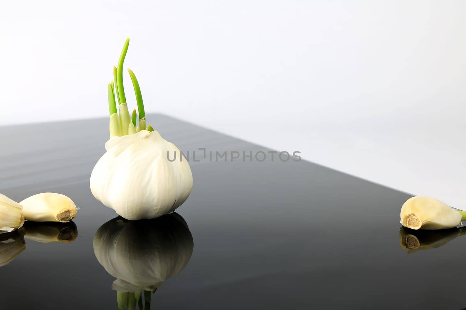 Garlic on a black plate wanders across the picture