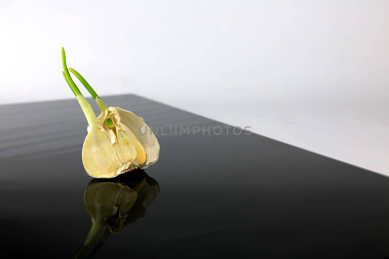 Garlic on a black plate wanders across the picture