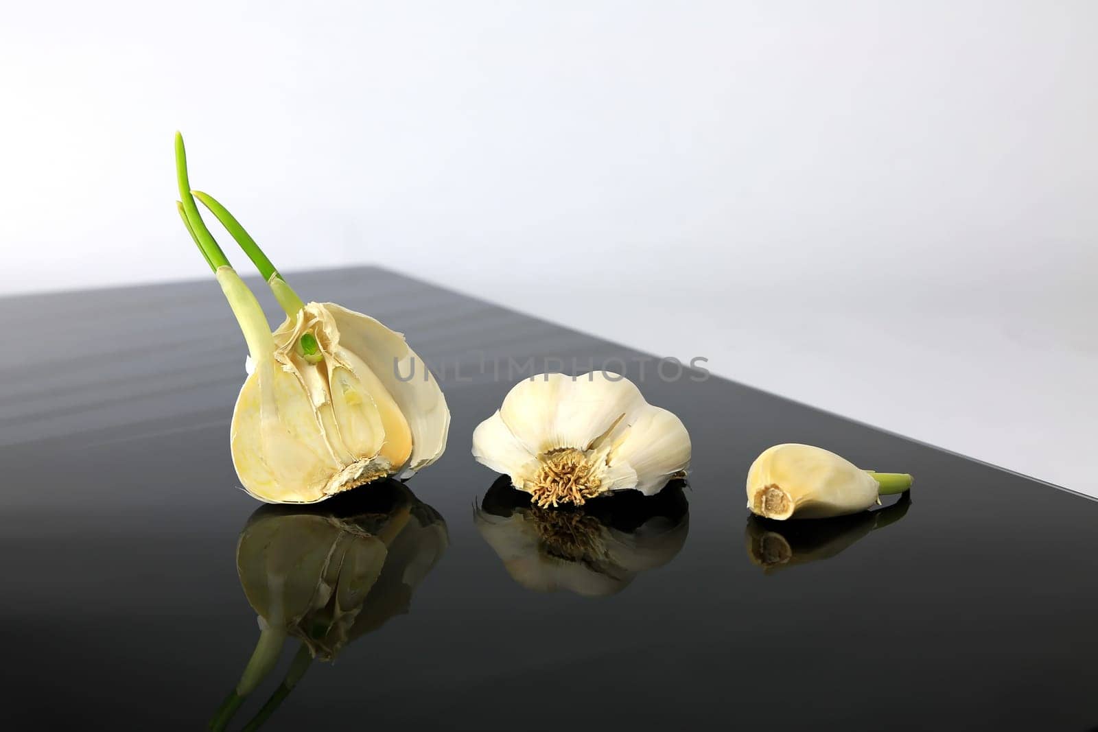 Garlic on a black plate wanders across the picture