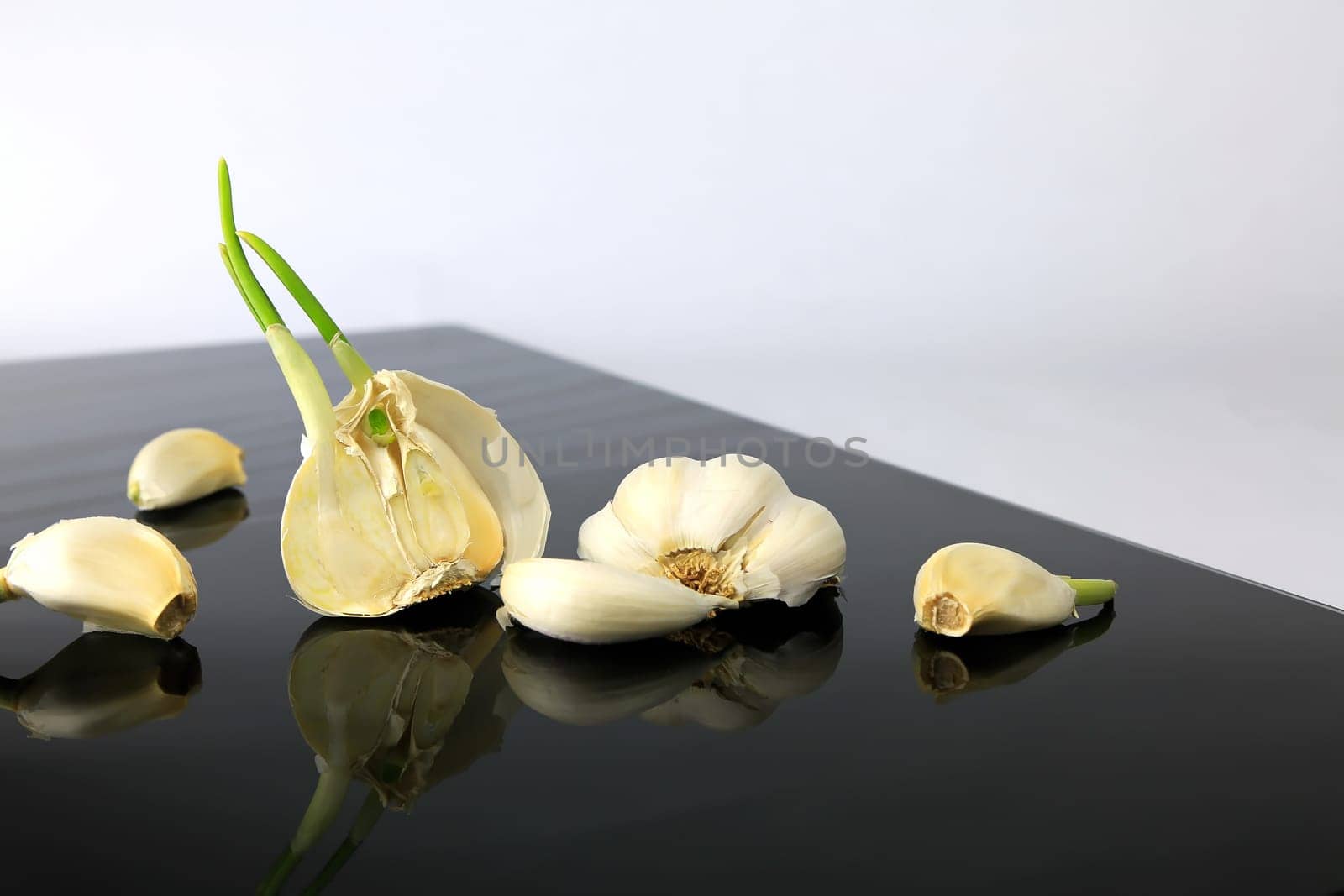 Garlic on a black plate wanders across the picture