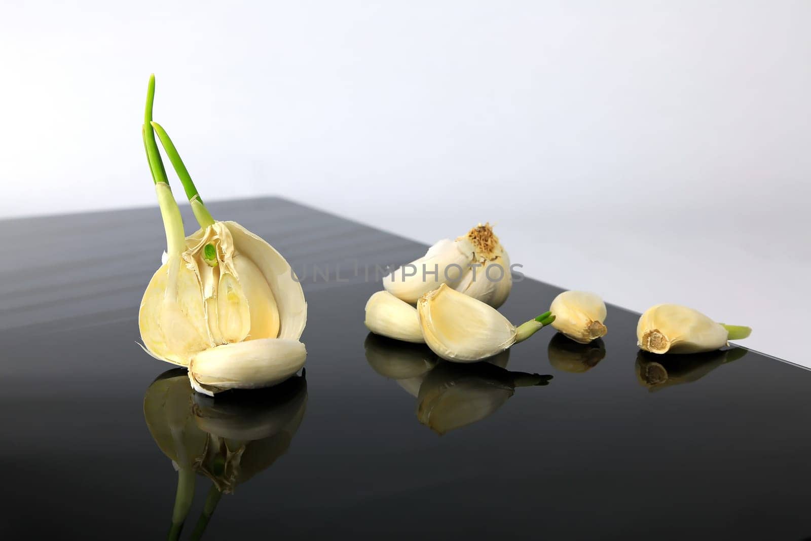 Garlic on a black plate wanders across the picture