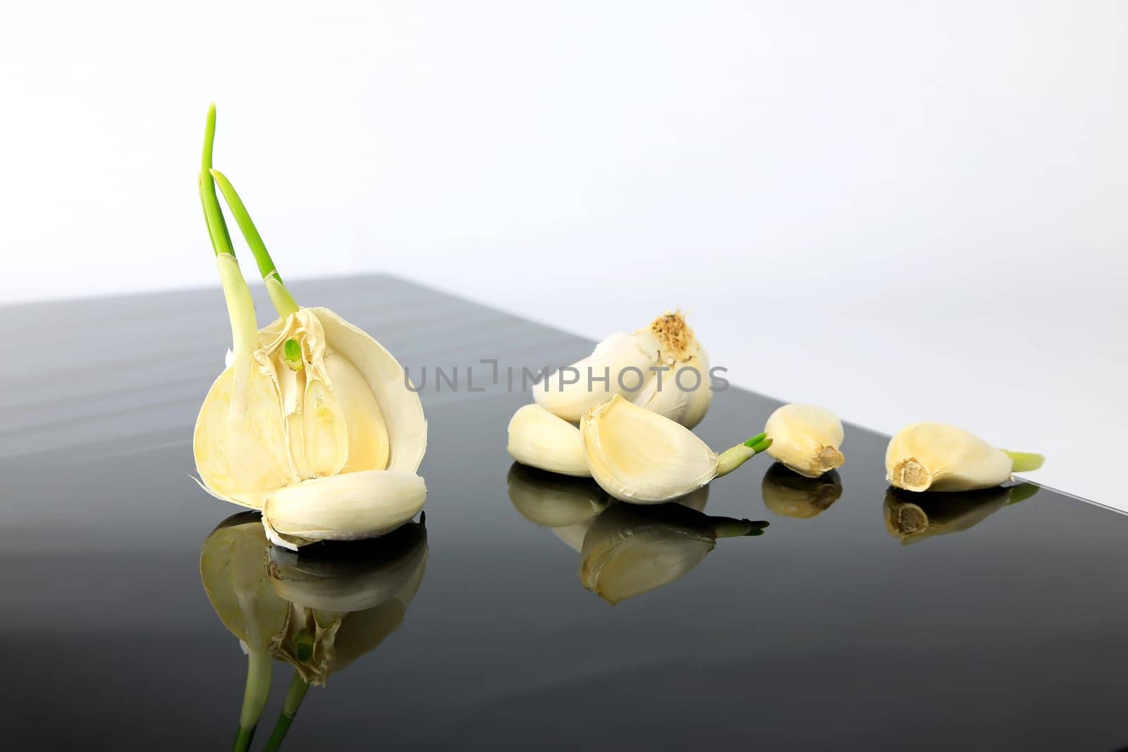 Garlic on a black plate wanders across the picture